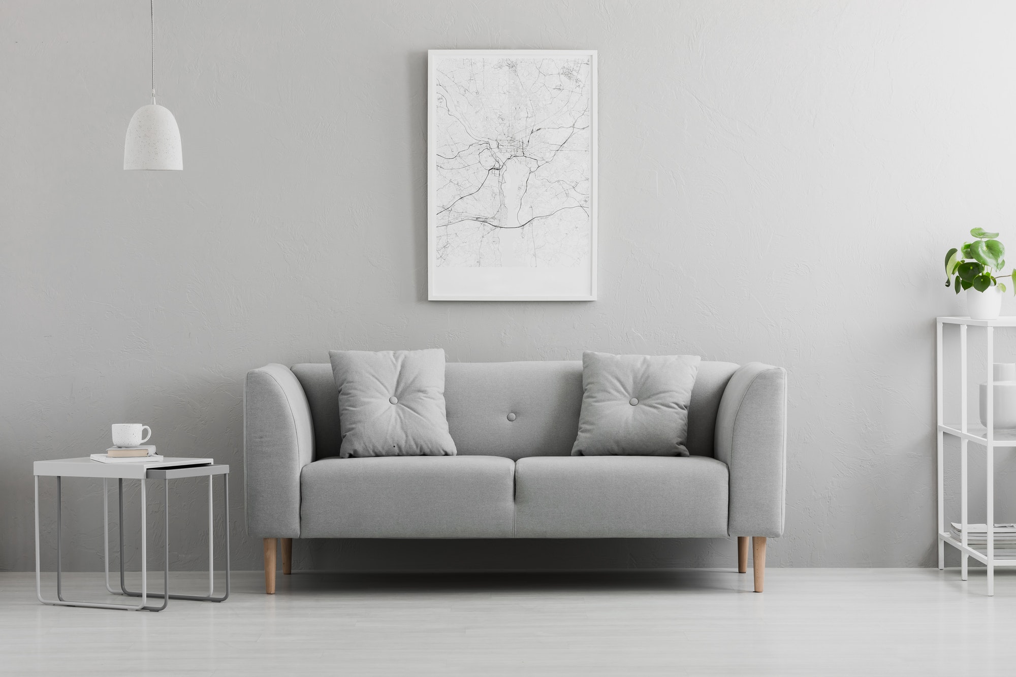 poster above grey couch in minimal living room interior with lam
