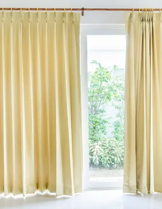 Thermal fabric curtains installed in a modern living room in Abu Dhabi, designed to regulate indoor temperature while enhancing interior style.